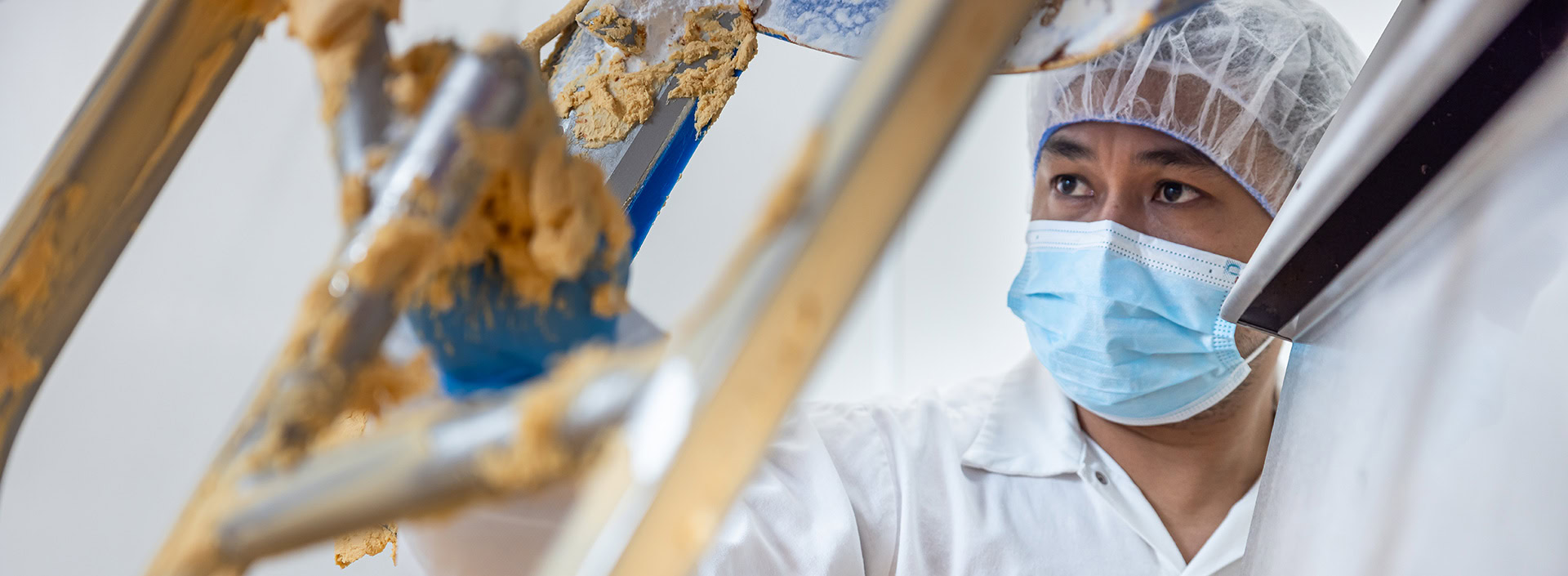 Commercial Bakeries team member cleaning a machine