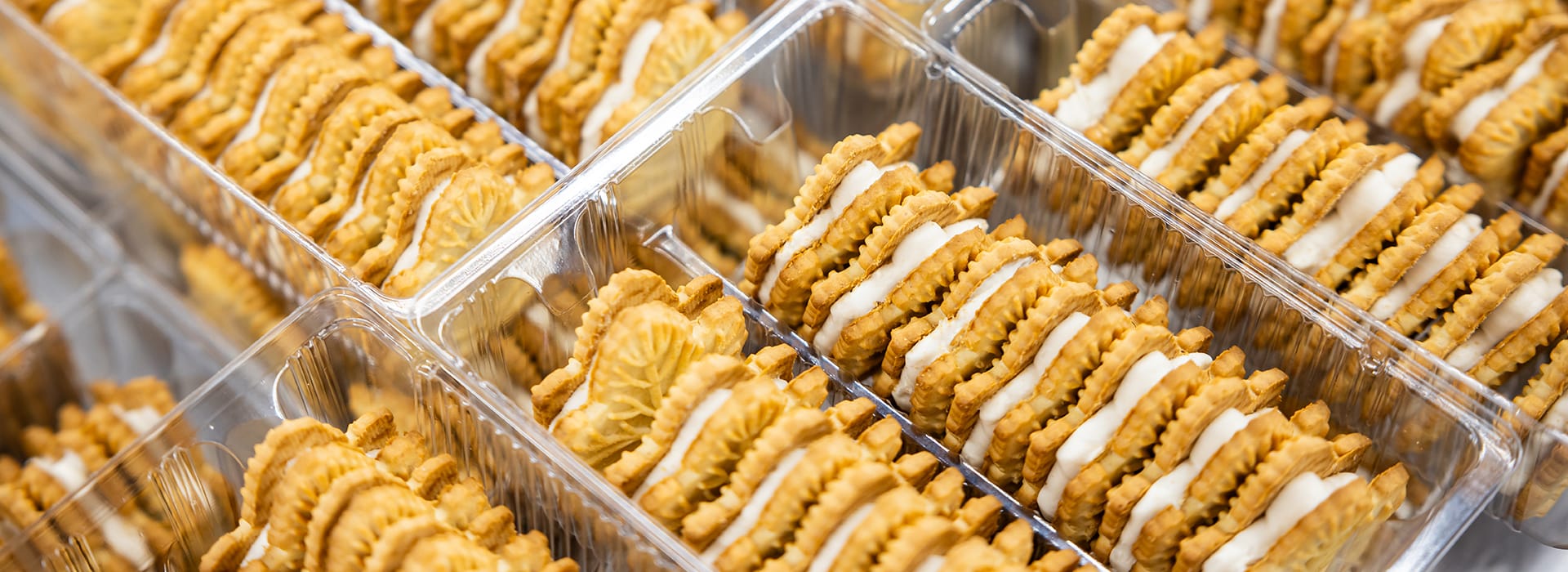 Assorted cookies arranged in clear plastic packaging.